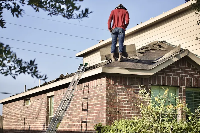Professional roofer working on a residential roof in Azalea Homes